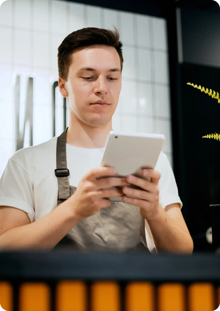 Operador de caixa conferindo as vendas no sistema Hermes Delivery Mobile